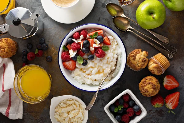 Стол для завтрака с рисовым пудингом, фруктами и кексами — стоковое фото