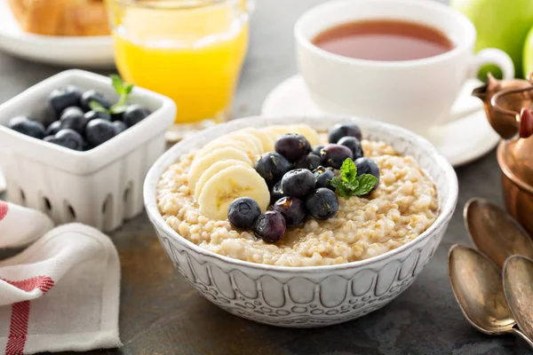 Stål cut havregryn gröt med banan och blåbär — Stockfoto