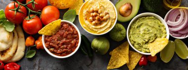 Ev yapımı Humus, salsa ve guacamole mısır cipsi ile