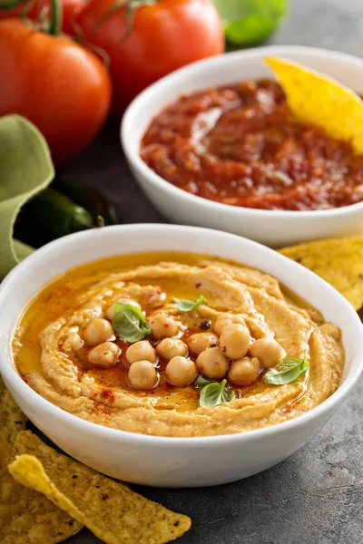 Hummus e salsa di pomodoro fatti in casa in ciotole bianche con patatine fritte — Foto Stock