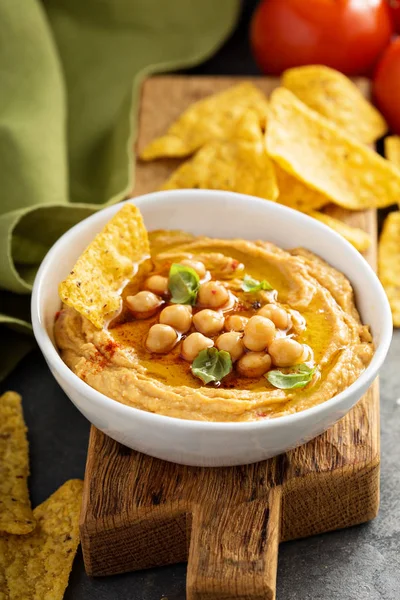 Hummus fait maison dans un bol blanc avec des copeaux de maïs — Photo