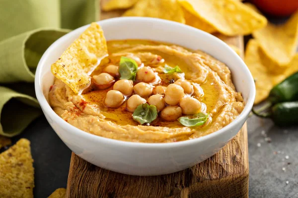 Hummus caseiro em tigela branca com chips de milho — Fotografia de Stock