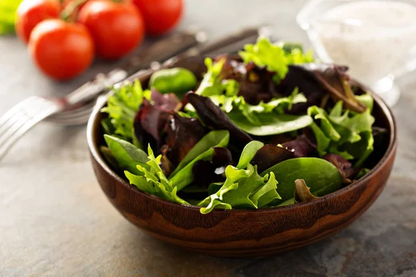 Frische Salatblätter in Holzschüssel — Stockfoto