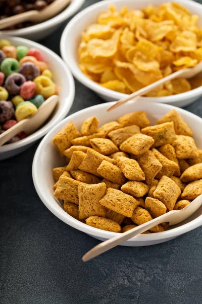 Variedad de cereales fríos en cuencos blancos con cucharas —  Fotos de Stock