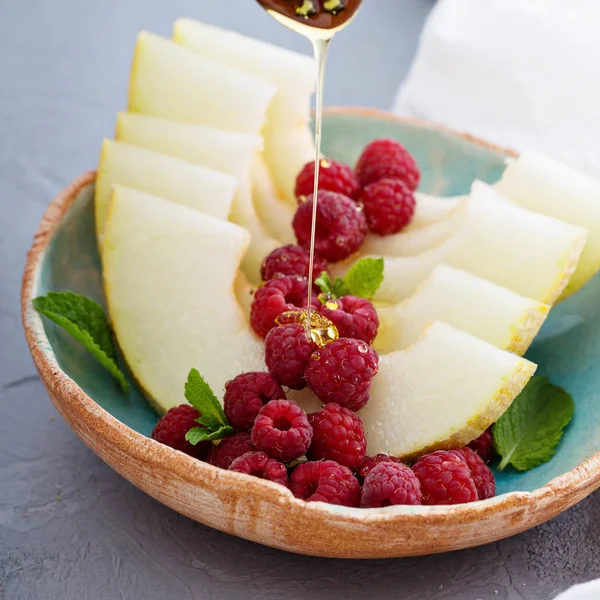 Rodajas de melón fresco con frambuesa y miel — Foto de Stock