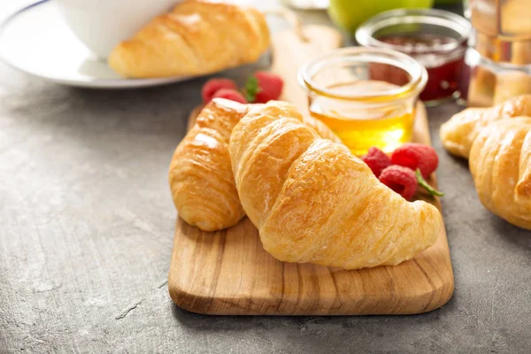 Croissants fraîchement cuits avec du miel et de la confiture — Photo