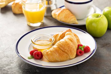 Taze pişmiş kruvasanlar bal ve reçel ile