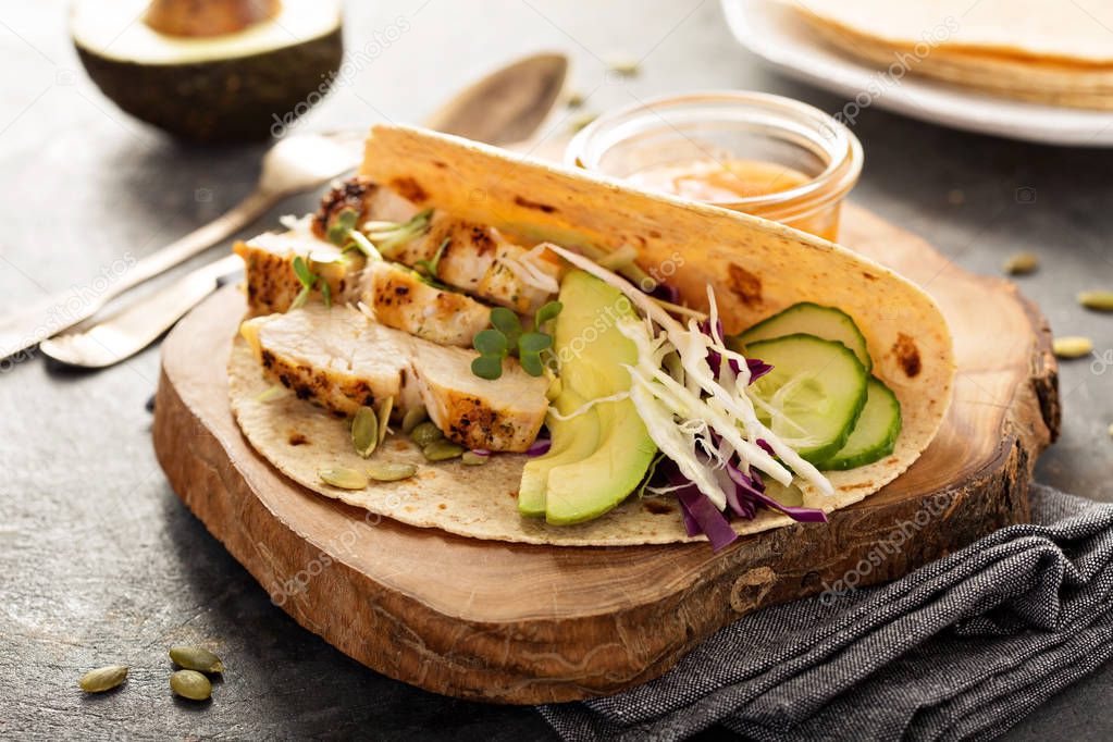 Making tacos with grilled chicken and avocado