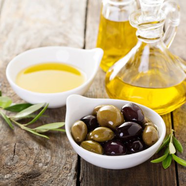 Şişe ve bir kase zeytin ile zeytinyağı