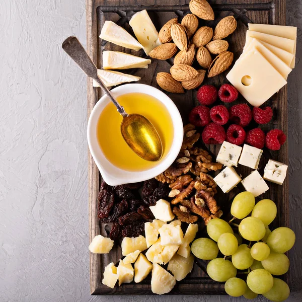 Cheese plate with nuts, honey and grapes — Stock Photo, Image