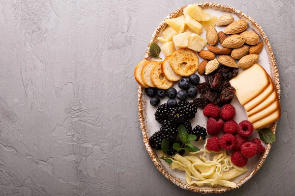 Placa de queso con frutos secos y bayas —  Fotos de Stock