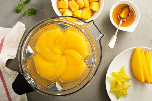 Making smoothie with frozen mango — Stock Photo, Image