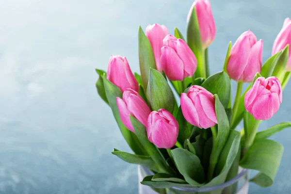 Tulipanes rosados en un jarrón de vidrio — Foto de Stock