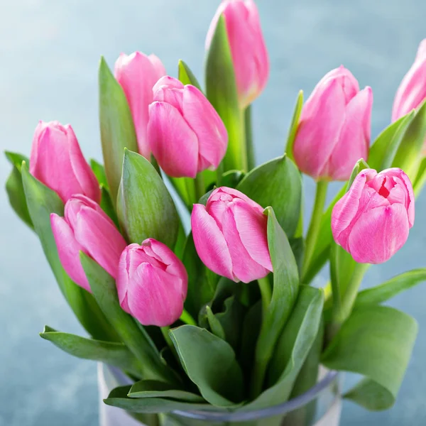 Tulipanes rosados en un jarrón de vidrio — Foto de Stock