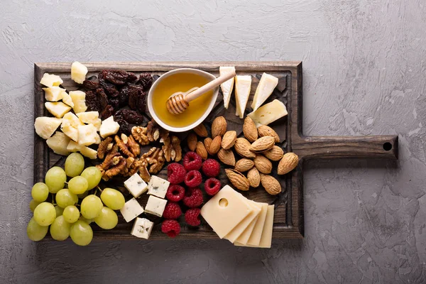 Cheese board with fruit and nuts — Stock Photo, Image
