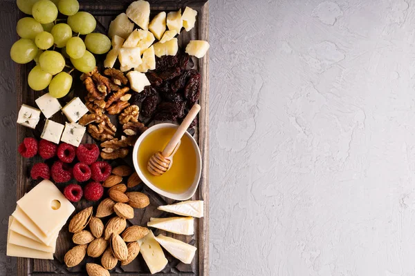 Cheese board with fruit and nuts — Stock Photo, Image