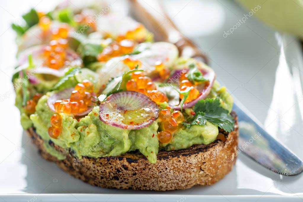 Gourmet avocado toast with caviar and radishes — Stock Photo