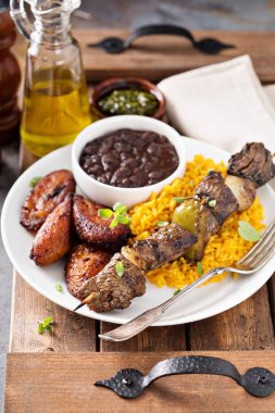 Beef kebab with rice, beans and fried plantains clipart