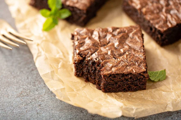 Freshly baked brownies on a parchment paper — Stock Photo, Image