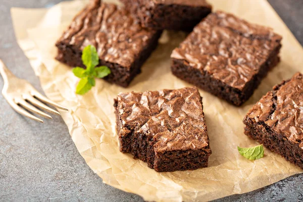 Freshly baked brownies on a parchment paper — Stock Photo, Image