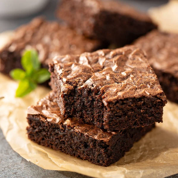 Freshly baked brownies on a parchment paper — Stock Photo, Image