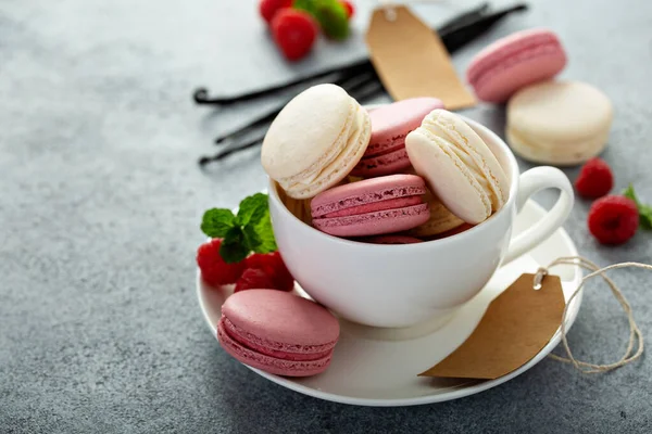 Macarrones de vainilla y frambuesa en una taza de té — Foto de Stock