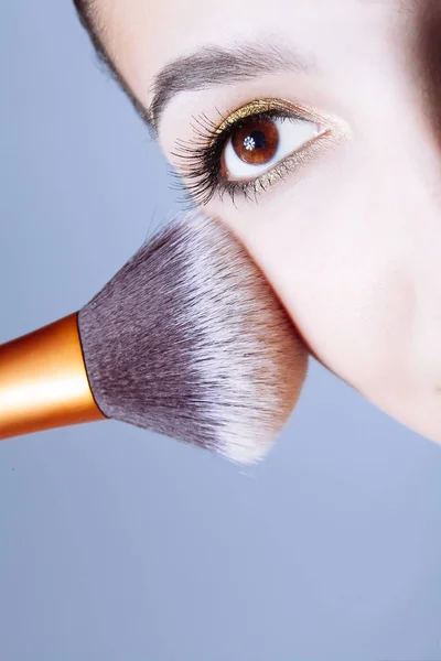 Visage de jeune femme obtenir de la poudre sur sa joue avec un pinceau . — Photo