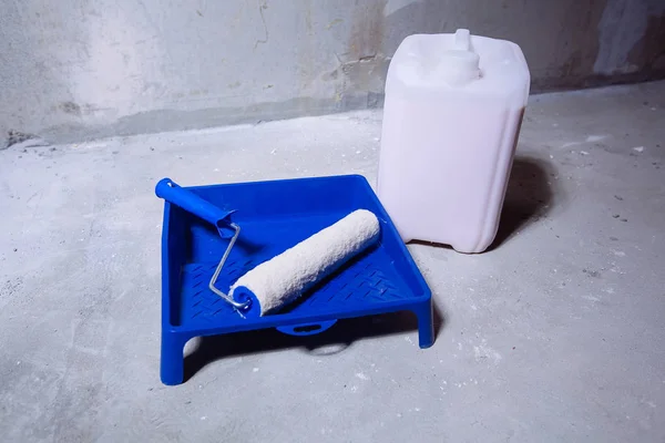 Balde vazio de tinta e uma bandeja de pintura de rolo de escova — Fotografia de Stock
