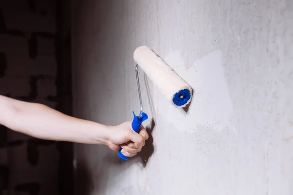 Primo piano delle mani mans utilizzando rullo di vernice durante il lavoro — Foto Stock