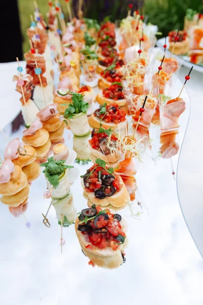 Mesa de banquete de catering lindamente decorada com comida diferente — Fotografia de Stock