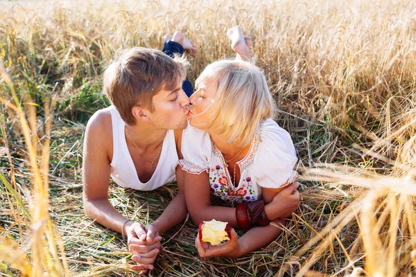 Imagen del hombre y la mujer jóvenes con manzanas en el campo de trigo — Foto de Stock