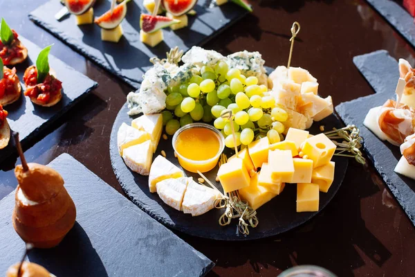 Placa de queso: Emmental, queso Camembert, queso azul con uva —  Fotos de Stock