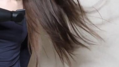 Siyah saç kurutma makinesiyle saç kurutan kadının videosunu kapat.