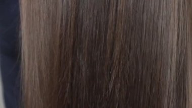 Uzun kahverengi kadın saçlarını taramak için tarak kullanarak, videoyu kapat