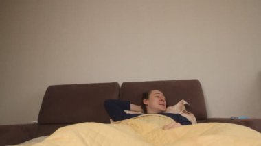  Uykucu Kafkasyalı bir adam sabah uyandığında elinde akıllı bir telefonla sosyal ağları ve haber kaynaklarını kontrol ediyor.