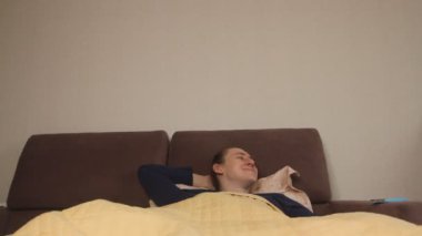  Uykucu Kafkasyalı bir adam sabah uyandığında elinde akıllı bir telefonla sosyal ağları ve haber kaynaklarını kontrol ediyor.