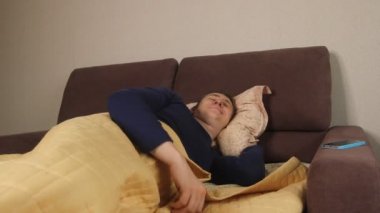  Uykucu Kafkasyalı bir adam sabah uyandığında elinde akıllı bir telefonla sosyal ağları ve haber kaynaklarını kontrol ediyor.