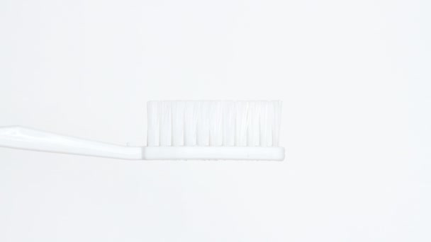 Zahnpasta Auf Eine Bürste Auf Weißem Hintergrund Geben — Stockvideo
