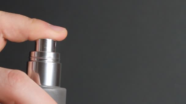 香水や熱水ガラスボトルを噴霧の閉鎖 黒の背景に化粧品ボトルの指押しポンプ — ストック動画