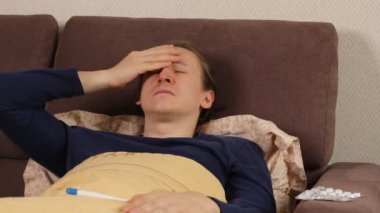 Sick young caucasian hipster man is lying in the bed cough and sneeze. Cold and flu, high body temperature