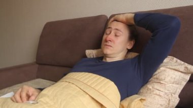 Sick young caucasian hipster man is lying in the bed cough and sneeze. Cold and flu, high body temperature