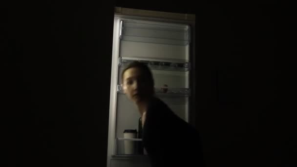 食事障害を持つ空腹の女性夜間に食べ物を取る冷蔵庫を見て 不健康な生活様式の概念 — ストック動画