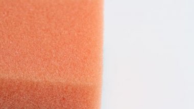 Blue dish washing liquid gel is pouring on orange sponge on white background 