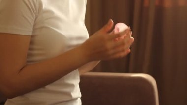 Genç bir kadının pembe ellerini tekrar kullanılabilir silikon aybaşı bardağıyla kapat. Sıfır atık adet hijyen konsepti.