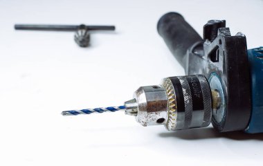 Genç adam elektrikli matkap hazırlıyor ve matkabı değiştiriyor.