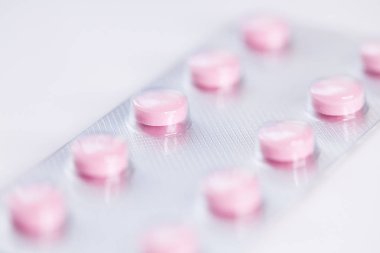Close up of pink   tablets, pills in blister pack, medications drugs, macro, selective focus