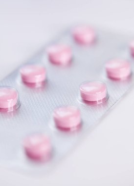 Close up of pink   tablets, pills in blister pack, medications drugs, macro, selective focus