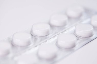 Close up of white tablets, pills in blister pack, medications drugs, macro, selective focus