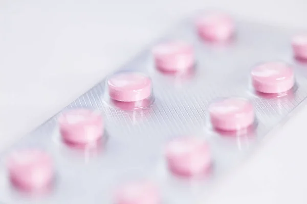 Close up of pink   tablets, pills in blister pack, medications drugs, macro, selective focus — ストック写真