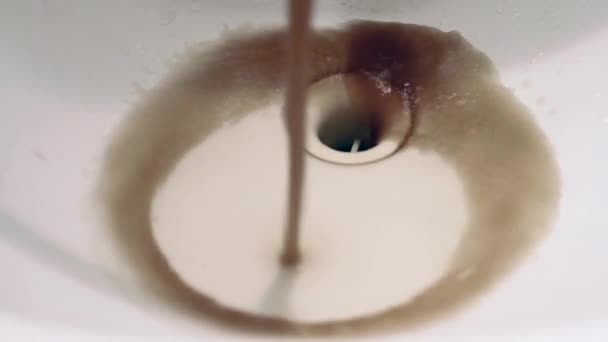 Close up vuil roestig bruin vervuild water stromen uit kraan in badkamer wastafel. — Stockvideo